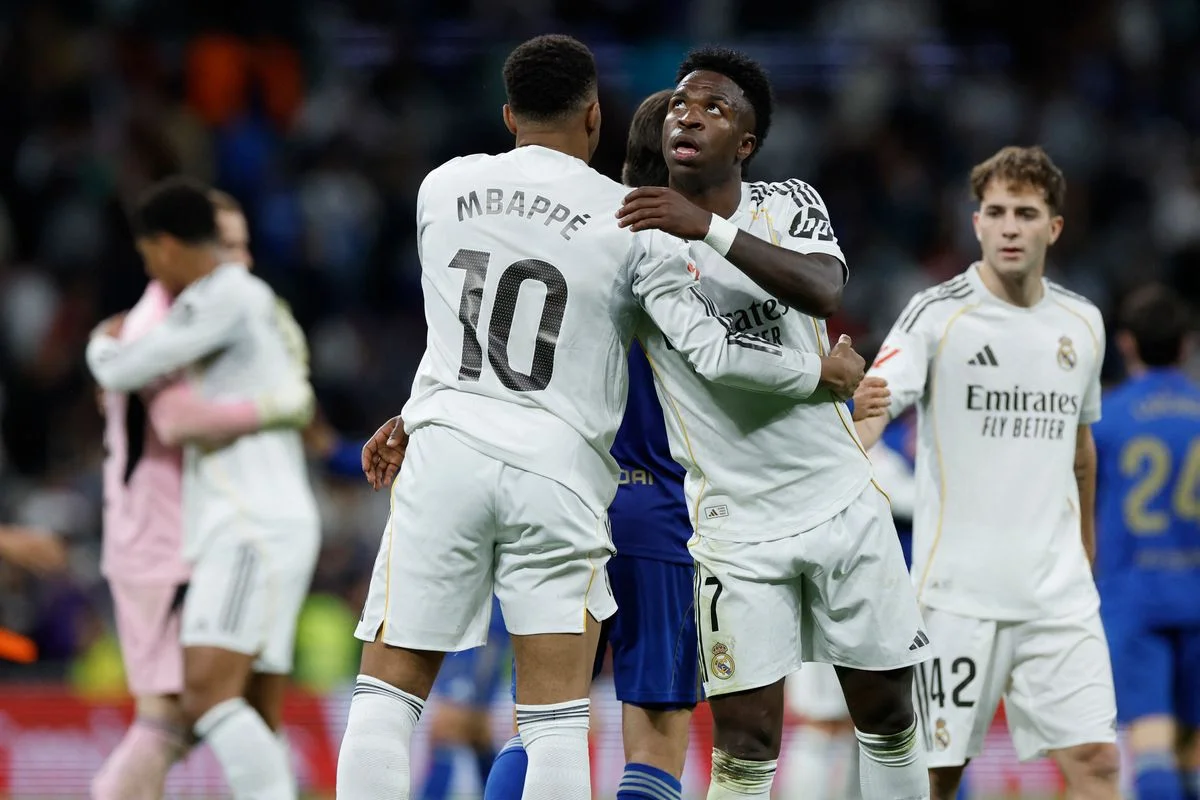 Real Madrid's French forward #10 Kylian Mbappe and Real Madrid's Brazilian forward #07 Vinicius Junior hug each other at the end of the Spanish league football match between Real Madrid CF and Real Oviedo at Santiago Bernabeu Stadium in Madrid on May 14, 2026. 